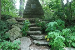 A picture of a cairn with 2 tombstones on either side of it.
