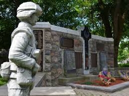 Picture of the cenotaph with a statue of a soldier standing to the side of it.
