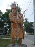 A tree sculpture in the shape of a Scottish piper.